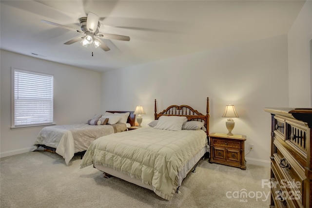 bedroom with ceiling fan, visible vents, baseboards, and light colored carpet