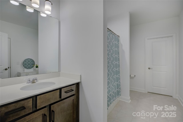 bathroom with tile patterned flooring, vanity, and baseboards