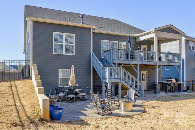 back of house with outdoor dining area, a patio, stairway, and fence