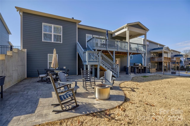 back of property featuring a deck, stairway, a patio area, and fence