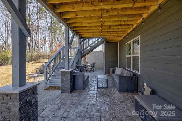 view of patio / terrace featuring fence, stairway, and an outdoor hangout area