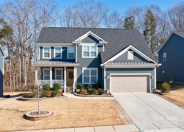 view of front of house with covered porch, concrete driveway, a standing seam roof, and a garage