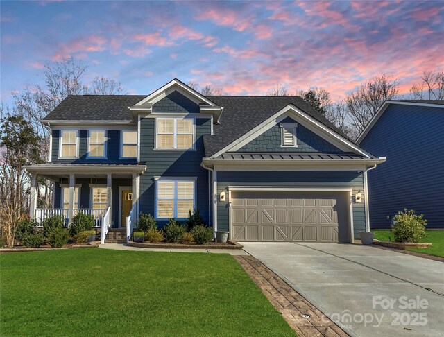 view of front of property featuring a lawn, concrete driveway, roof with shingles, an attached garage, and covered porch