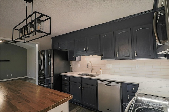 kitchen featuring wooden counters, sink, a textured ceiling, dark hardwood / wood-style flooring, and stainless steel appliances