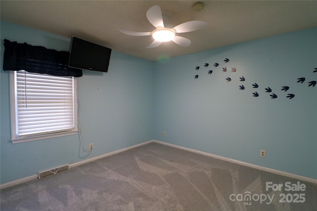 carpeted spare room with ceiling fan