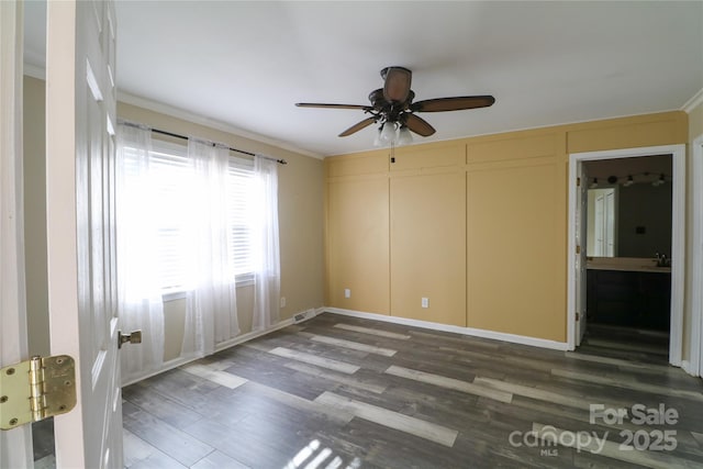 empty room featuring dark hardwood / wood-style floors, ceiling fan, and ornamental molding