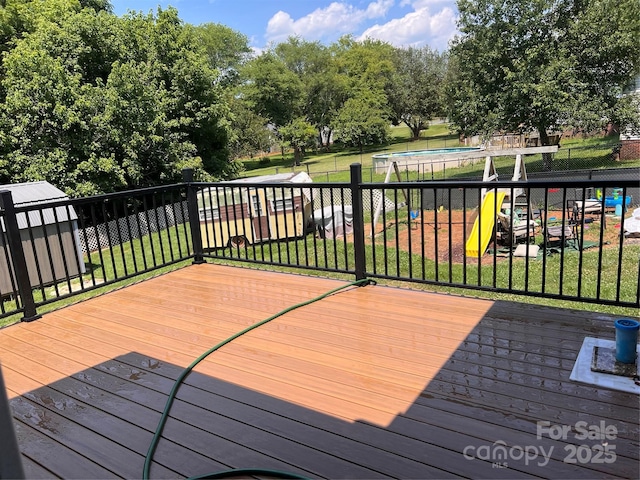 deck with a lawn, a storage shed, and a trampoline