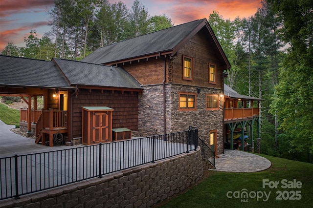 back house at dusk featuring a wooden deck