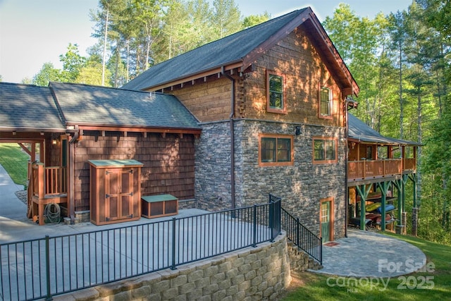 back of property featuring a patio and a wooden deck