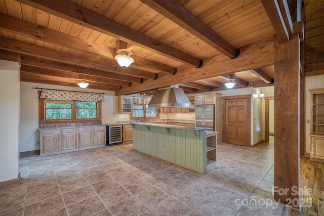 kitchen featuring wood ceiling, beverage cooler, exhaust hood, a center island, and stainless steel refrigerator