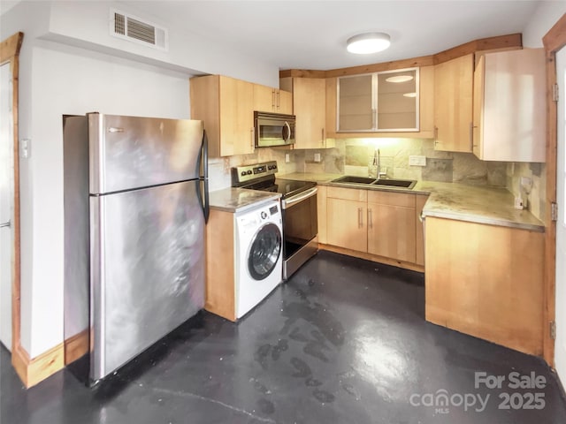 kitchen with light brown cabinets, sink, tasteful backsplash, stainless steel appliances, and washer / clothes dryer