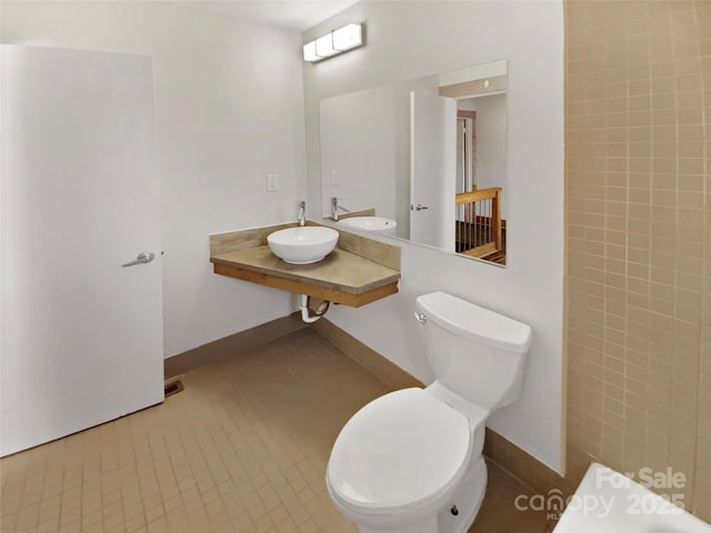 bathroom with tile patterned flooring, toilet, and sink