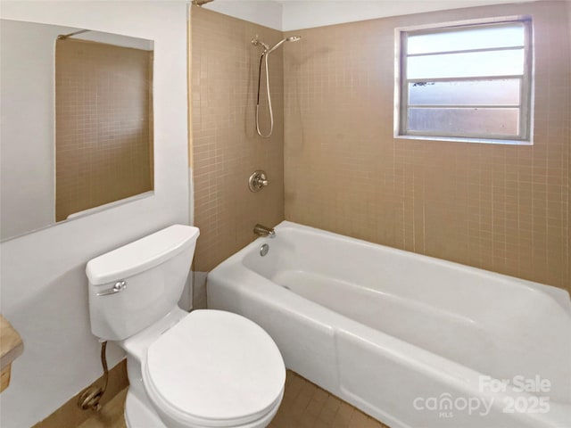 bathroom featuring toilet and tiled shower / bath