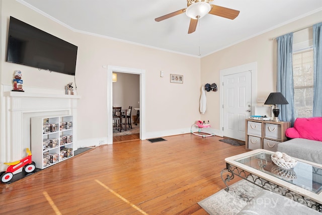 living room with ceiling fan, wood-type flooring, and crown molding