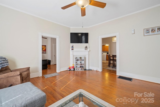 living room with ceiling fan, ornamental molding, and hardwood / wood-style flooring