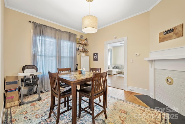 dining space with light wood-type flooring and ornamental molding