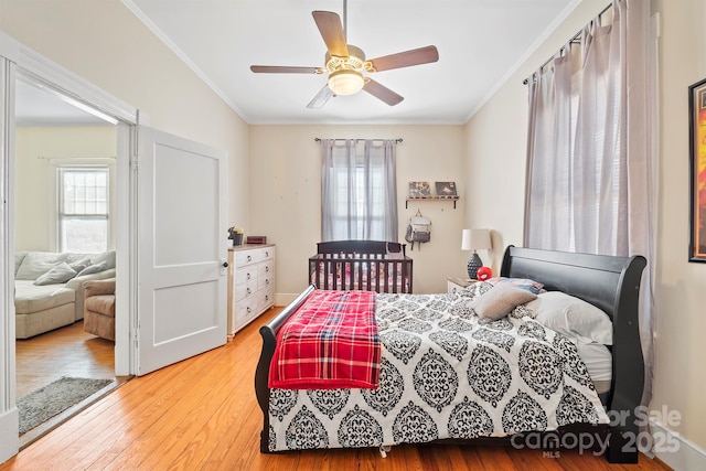 bedroom featuring hardwood / wood-style floors, ceiling fan, and crown molding