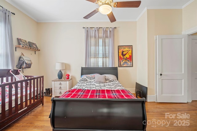 bedroom with light hardwood / wood-style flooring, ceiling fan, and ornamental molding