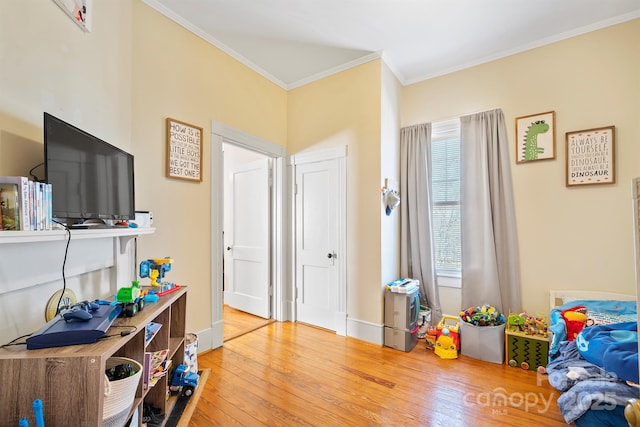 game room with light wood-type flooring and ornamental molding