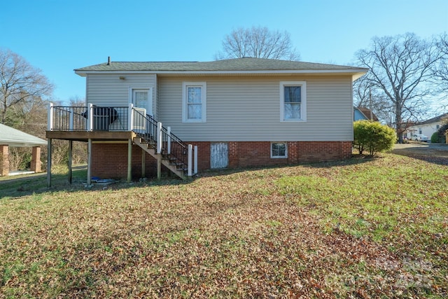 rear view of property featuring a yard and a deck