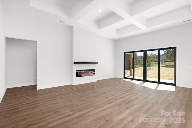 unfurnished living room with hardwood / wood-style floors, coffered ceiling, and beam ceiling