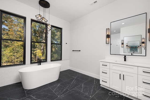 bathroom featuring plenty of natural light, vanity, a bath, and tile walls