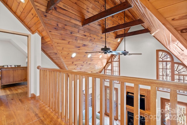 hall featuring high vaulted ceiling, wood finished floors, wood ceiling, baseboards, and beamed ceiling