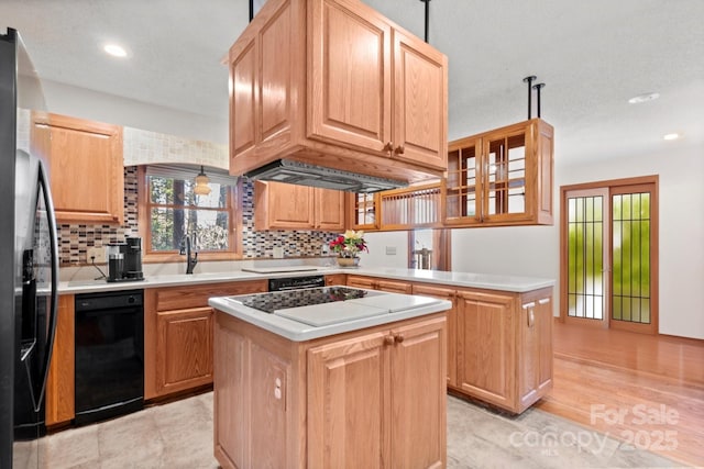 kitchen with a center island, backsplash, light countertops, and refrigerator with ice dispenser