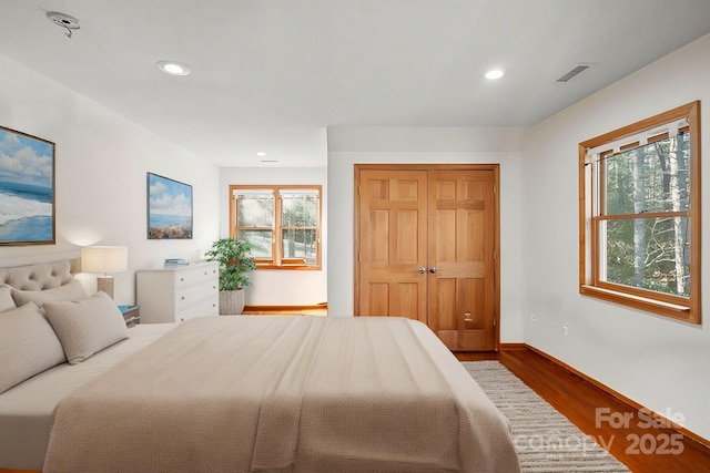 bedroom featuring recessed lighting, visible vents, baseboards, and wood finished floors