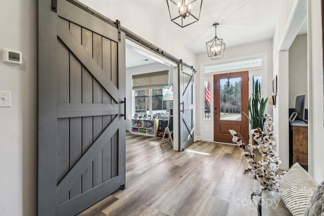 foyer featuring a chandelier, hardwood / wood-style floors, and a barn door