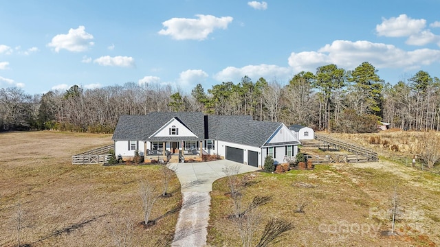 view of front of property with covered porch, a garage, and a front yard