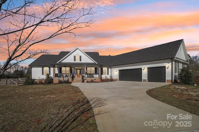 modern farmhouse style home with covered porch, a yard, and a garage