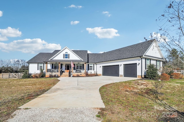 view of front of house featuring a garage, covered porch, and a front lawn