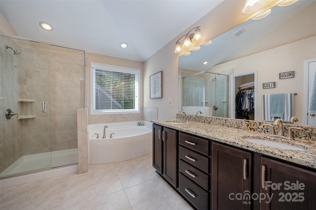 bathroom featuring tile patterned floors, shower with separate bathtub, vaulted ceiling, and vanity