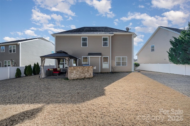 back of property featuring a gazebo