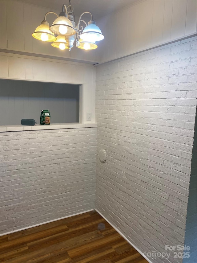 110 Heywood Rd Unit 20, Arden, NC 28704 - spare room with brick wall, dark wood-style floors, and a chandelier
