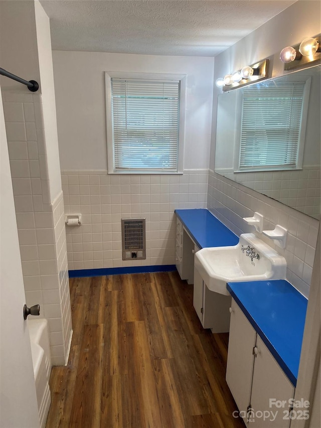 110 Heywood Rd Unit 20, Arden, NC 28704 - bathroom featuring tile walls, heating unit, wood finished floors, vanity, and wainscoting