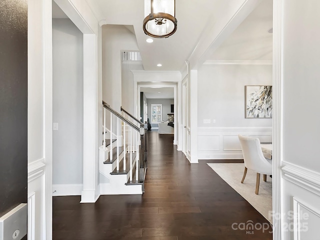 entrance foyer featuring crown molding and dark hardwood / wood-style flooring