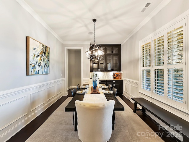 dining area with an inviting chandelier and crown molding