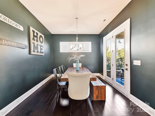 dining room featuring dark hardwood / wood-style flooring and an inviting chandelier