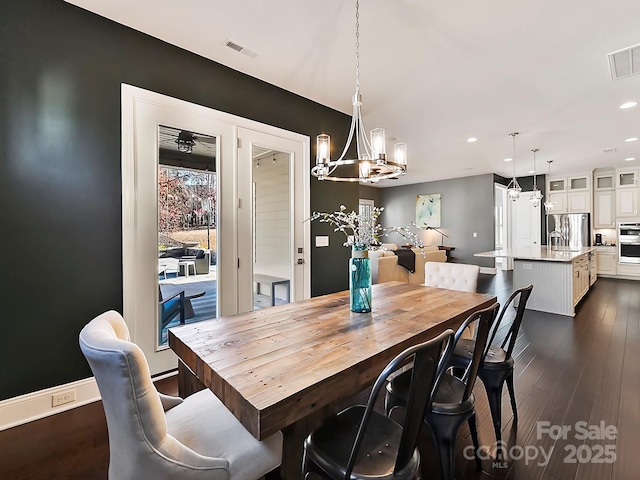 dining room with a notable chandelier and dark hardwood / wood-style flooring