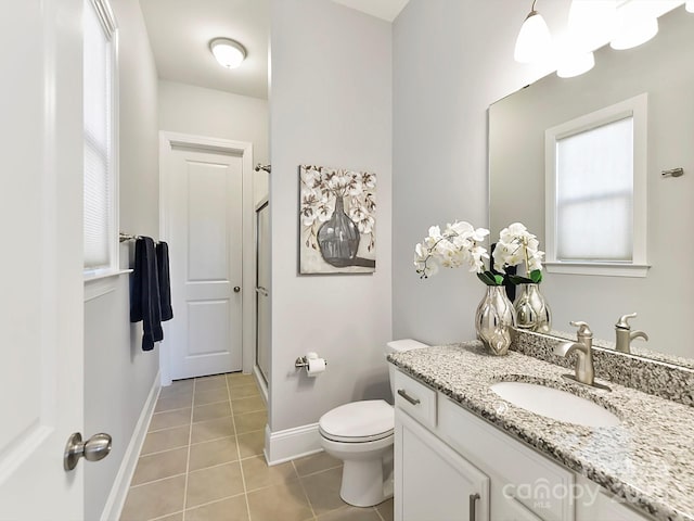 bathroom featuring tile patterned flooring, vanity, a shower with door, and toilet