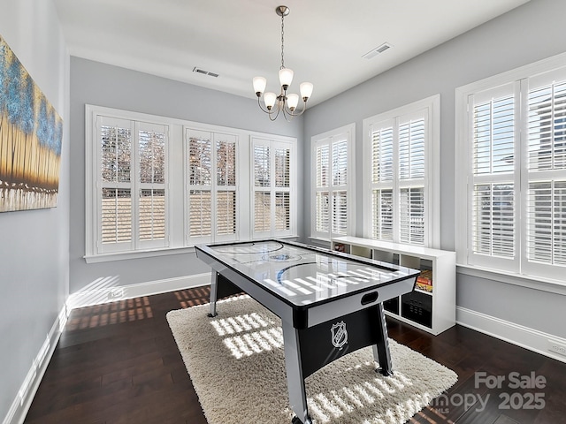 playroom featuring dark wood-type flooring and a chandelier