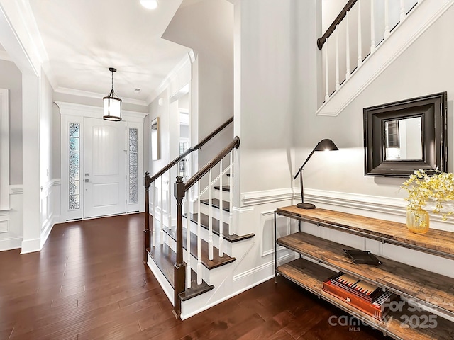 entryway with ornamental molding and dark hardwood / wood-style floors