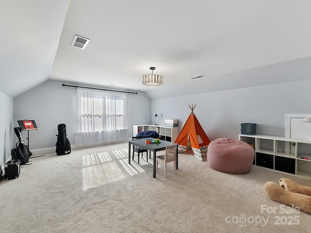 playroom with an inviting chandelier, vaulted ceiling, and carpet