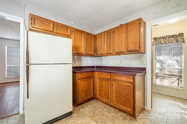 kitchen with white fridge and a textured ceiling