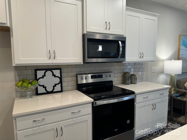 kitchen featuring white cabinets, light stone counters, backsplash, and appliances with stainless steel finishes