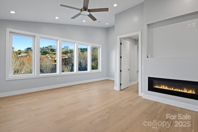 unfurnished living room featuring ceiling fan, light hardwood / wood-style flooring, and vaulted ceiling