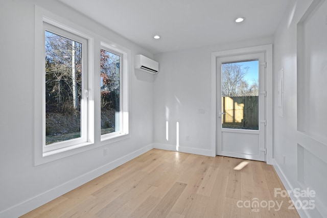 unfurnished dining area with light hardwood / wood-style floors and a wall unit AC