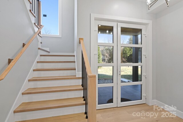 stairway featuring wood-type flooring and a wealth of natural light